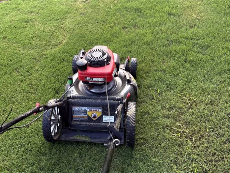 Push mower on a freshly cut lawn during a Bastrop, TX mowing visit