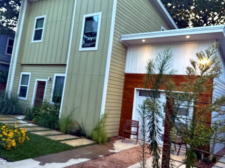 Stone paver path and native plantings at a modern home entrance in Bastrop
